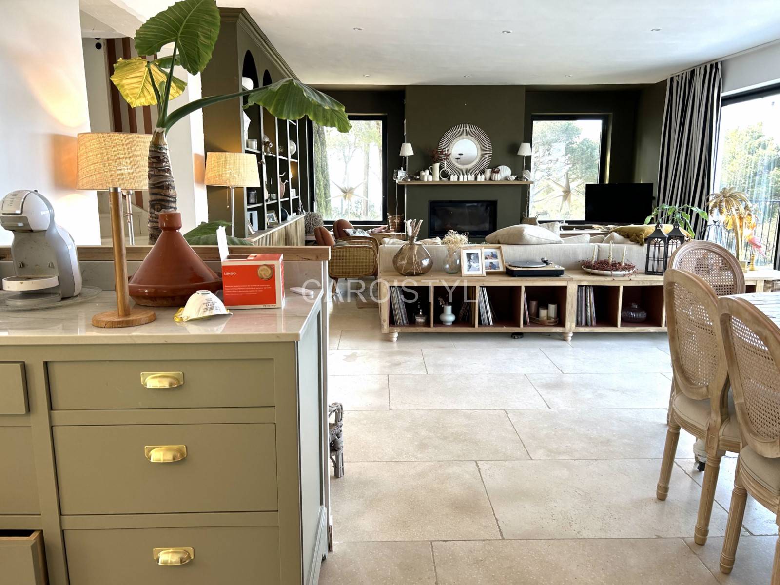 Vue sur une salle à manger mêlant sol en Sangis Blanche lisse et mur d’accent en pierre, pour un jeu de textures raffiné et tendance.