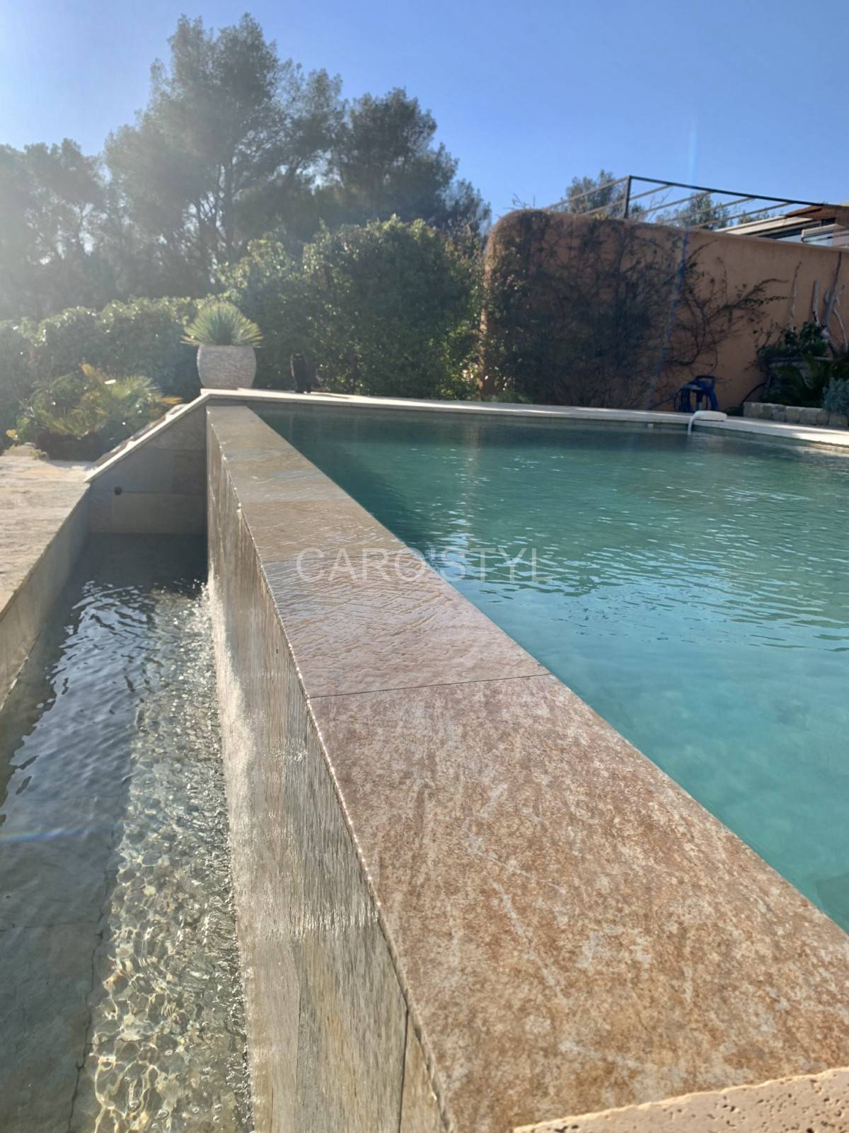 Piscine à débordement avec des carreaux sable de phuket Marseille